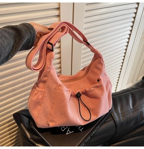 Close-up of pink corduroy shoulder bag with silver sequins and adjustable strap