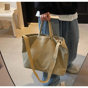 Detail showing the large capacity canvas tote bag with reinforced handles and wide strap