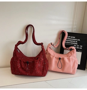 Detailed close-up of corduroy crossbody bags in dark red and pink with adjustable straps