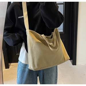 Detail view of large canvas tote bag with thick shoulder straps and durable fabric texture