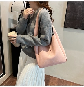 Chic Morandi pink suede tote bag worn with grey sweater and pleated skirt for causal look