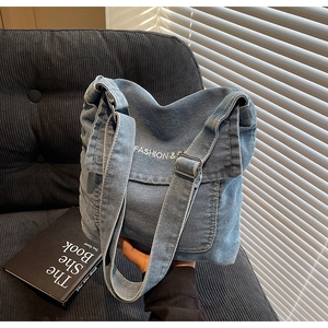 Dettaglio ravvicinato della borsa a tracolla in denim blu con fibbia in metallo
