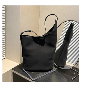 Detail view of black tote bag showing vertical double stitching and smooth matte texture