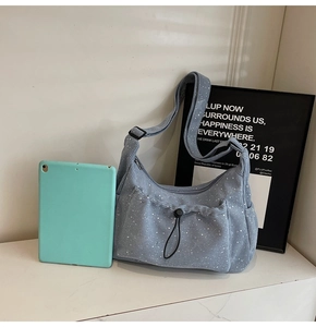 Detail of blue corduroy crossbody bag with white polka dots and drawstring pocket