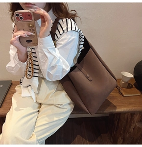 Brown frosted leather tote bag shown on a model highlighting its size and drape