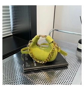 Detalle del bolso media luna de ante verde lima con cadena dorada y hebilla metálica