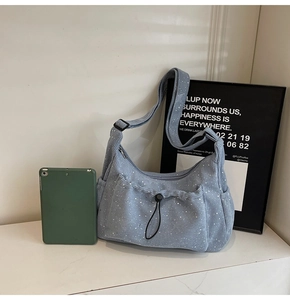 Detail of light blue corduroy crossbody bag with white polka dots and adjustable strap