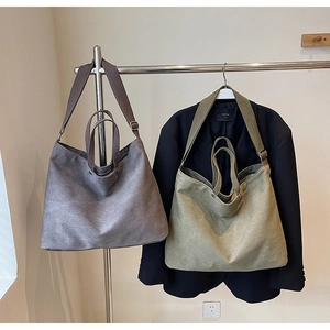 Detail of heavy canvas tote bags in grey and olive green with double handle design