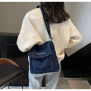Dettaglio della borsa a tracolla in denim blu scuro con testo logo FASHION & BAGS