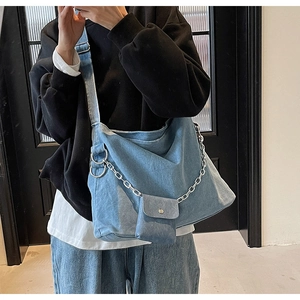 Detail of blue denim tote bag with silver chain strap and small detachable coin purse