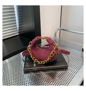 Detalle de bolso de media luna en ante violeta con cadena dorada y correa de hombro ajustable