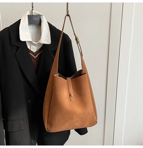 Close-up of vintage brown matte shoulder bag with gold buckle and wide strap
