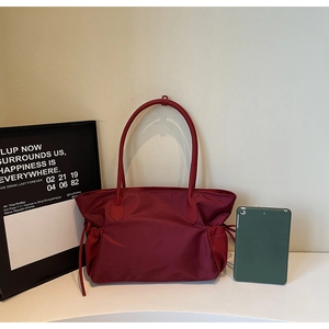 Détail du sac de voyage en nylon imperméable bordeaux avec cordon de serrage et anses