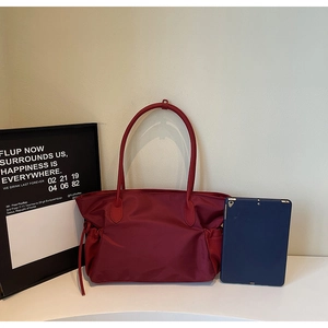 Grand sac de voyage en nylon bordeaux plissé avec une tablette bleue pour l'échelle