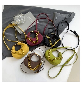 Vista detallada de mini bolsos bandolera de media luna en cinco colores y cadena de oro