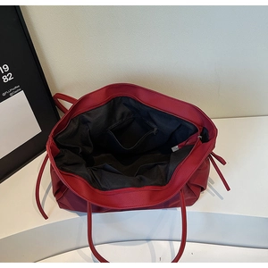 Vue intérieure du sac fourre-tout rouge montrant la doublure noire et poches internes