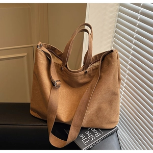 Detail of camel canvas tote bag showing top zipper and adjustable shoulder strap