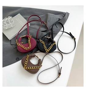 Tres elegantes bolsos cruzados de media luna en burdeos, negro y café con cadena dorada