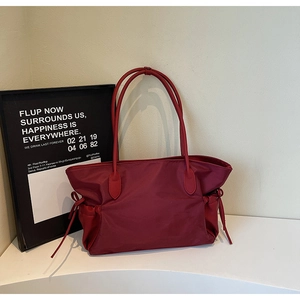 Vue détaillée du sac de voyage bordeaux en nylon imperméable avec cordons de serrage latéraux