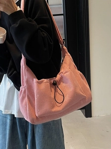 Pink pleated corduroy crossbody bag with silver glitter and adjustable strap shown on model