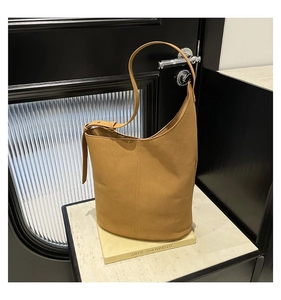 Detail view of camel bucket bag showing adjustable shoulder strap and leather texture