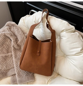 Detail of a brown vintage hobo bag featuring adjustable metal buckle and magnetic closure