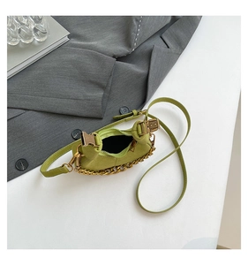 Detalle de bolso medialuna verde aguacate con cadena dorada y textura de ante