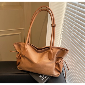Détail d'un sac cabas marron en nylon et similicuir avec cordons de serrage latéraux