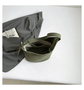 Top view of olive green bucket bag interior with light gray lining and a zipper pocket