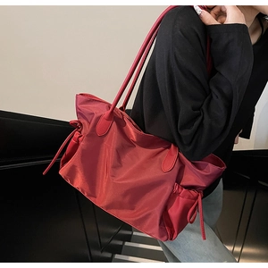 Détail du grand sac cabas rouge en nylon avec cordons de serrage et anse en cuir