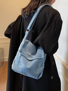 Borsa a tracolla in denim azzurro con ricamo bianco e ampia tracolla regolabile