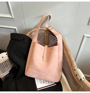 Close-up of pink hobo shoulder bag with matte finish on a vintage wicker chair