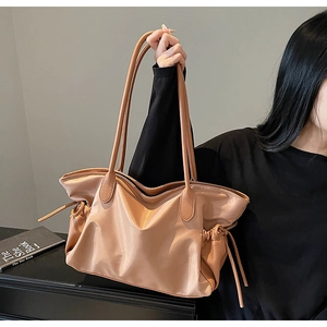 Détail du grand sac de voyage kaki avec cordon de serrage et design en similicuir brillant