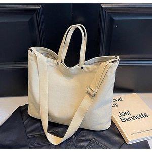 Detail of canvas tote bag showing thick texture and adjustable shoulder strap