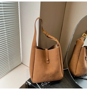 Detail of caramel suede hobo bag featuring adjustable golden buckle and matte texture
