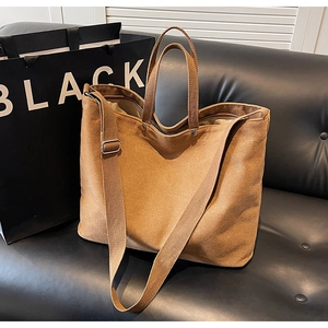Detailed texture of thick khaki canvas tote bag with adjustable wide shoulder strap