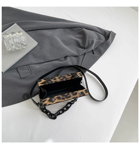 Λεπτομέρεια ορθογώνιας τσάντας με λεοπάρ σχέδιο, μαύρη αλυσίδα και λεπτό λουράκι ώμου