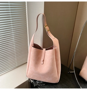 Detail of matte peach pink tote bag showing the high-quality suede texture and golden buckle