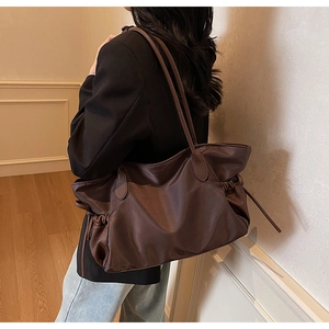 Détail du sac cabas marron foncé avec côtés à cordon réglable et bandoulières