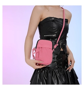 Detail of pink washed denim mini crossbody bag with zipper and adjustable shoulder strap