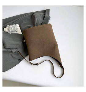 Detail of adjustable strap and brown suede texture on minimalist bucket bag for women