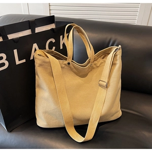 Detail of khaki heavy-duty canvas tote showing thick texture and metal rivet accents