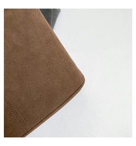 Close-up of brown suede leather bag featuring exquisite stitching and premium texture detail