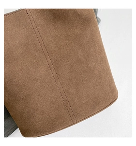 Detail of brown suede bucket bag featuring durable double-row reinforced stitching