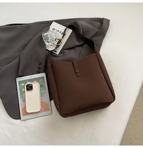 Detail view of large dark brown matte shoulder bag with magnetic strap closure