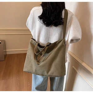 Rear view of model wearing a large khaki canvas tote bag for daily commute and students