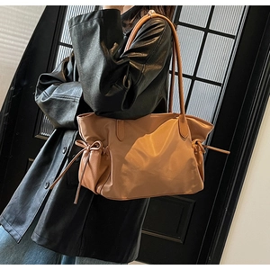 Gros plan du sac de voyage en nylon marron avec détails de nœuds à cordon latéraux