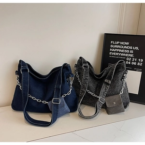 Detail of vintage denim tote bags with silver chains and mini pouches in blue and grey