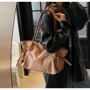 Vue détaillée du grand sac de voyage abricot avec cordon de serrage et cuir texturé