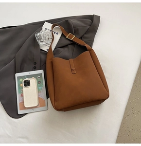 Detail of caramel suede tote bag with adjustable gold buckle for commute look